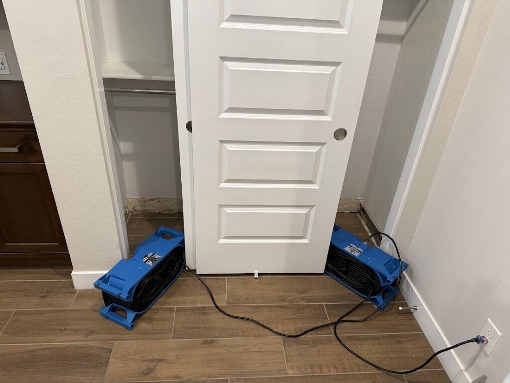 Two industrial drying fans placed in a closet to mitigate water damage by Flow State Restoration in Gilbert, AZ