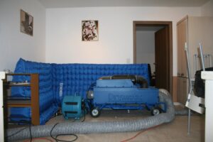 A Drymatic water damage drying system with hoses set up in a room for restoration by Certified Restoration in San Diego, CA