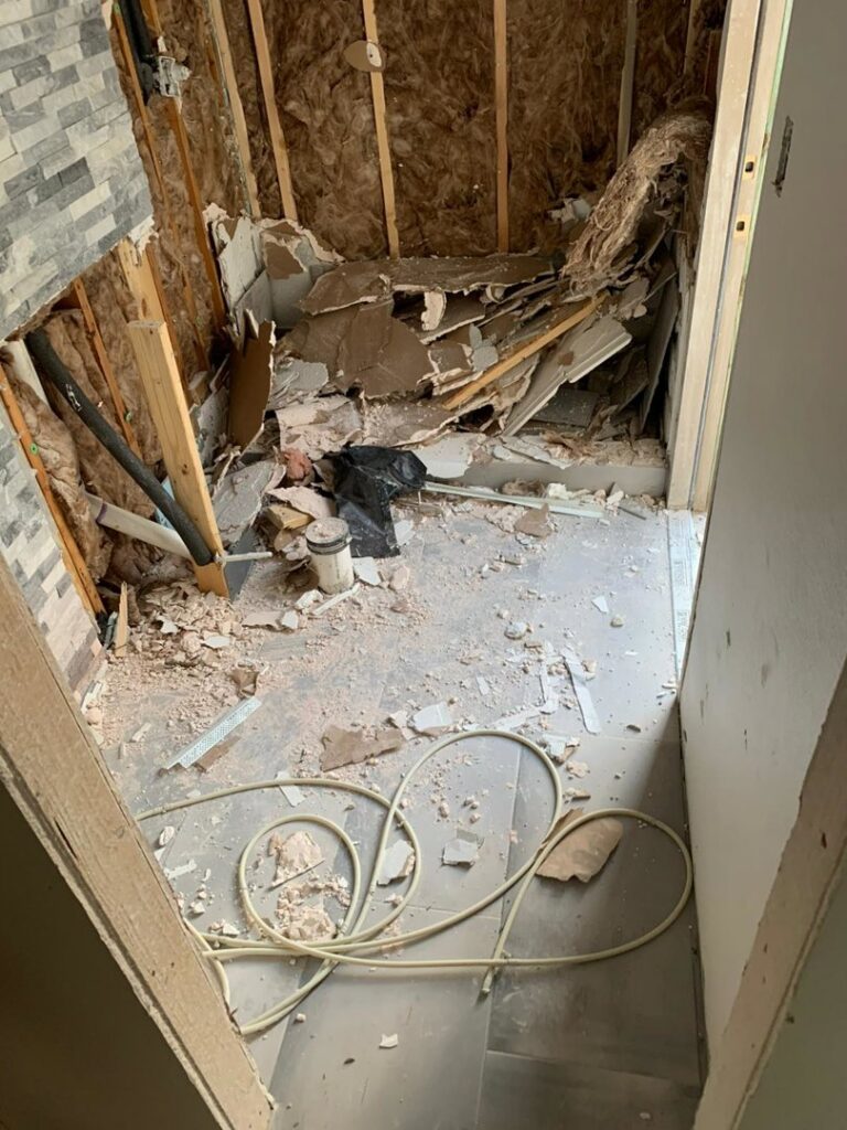 An interior room filled with drywall and construction debris after a demolition project by Vaquero Demolition in Lewisville, TX.