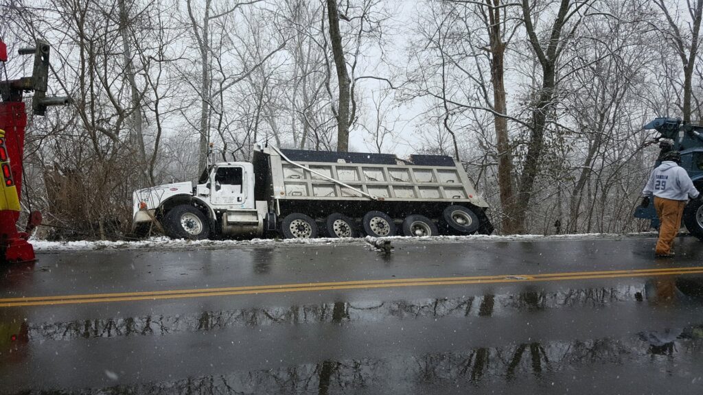 Bevis Towing performing a dump truck recovery from a snowy ditch on the side of a road in Cincinnati, OH.
