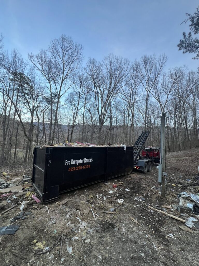 A dumpster being delivered to a demolition cleanup site by Pro Dumpster Rentals in Chattanooga, TN.