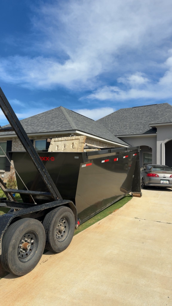 A roll-off dumpster filled with demolition debris, including bricks and concrete, by JP4 LLC in Bossier City, LA.