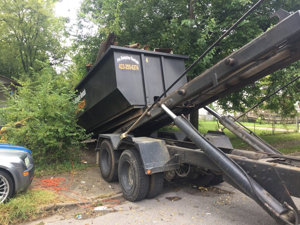 A dumpster full of demolition debris being hauled away by Pro Dumpster Rentals in Chattanooga, TN.