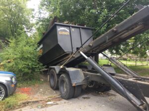 A dumpster full of demolition debris being hauled away by Pro Dumpster Rentals in Chattanooga, TN.