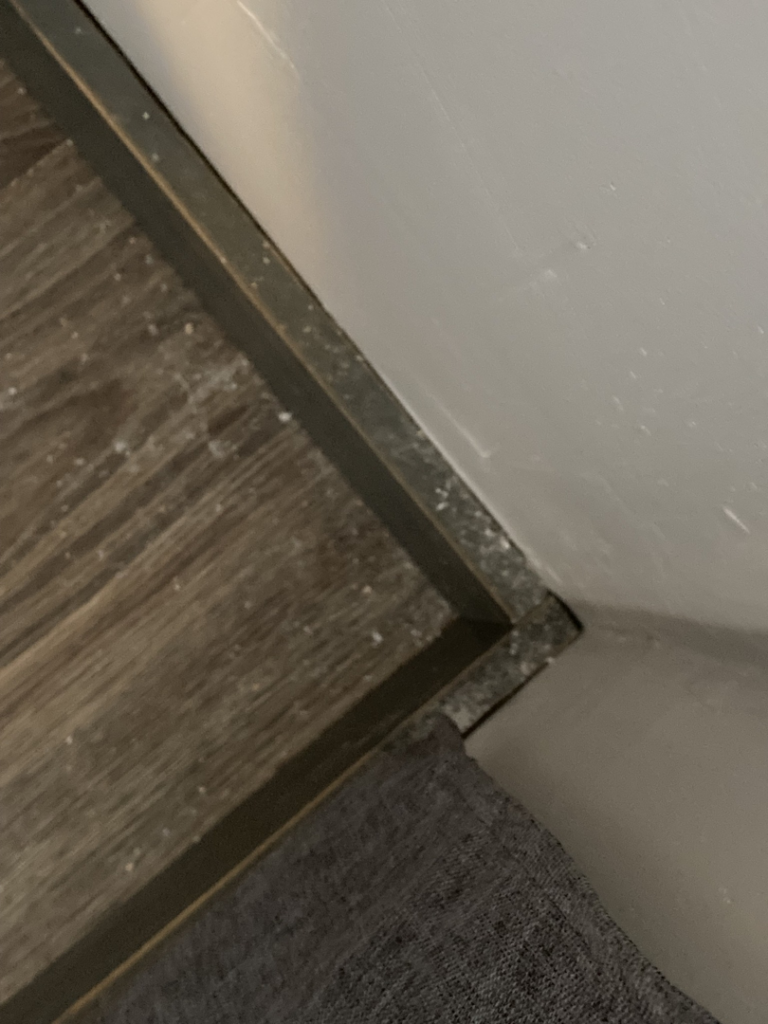 Dust and debris accumulated along a baseboard, ready for cleaning by G & S Cleaning Services in Somerville, NJ.