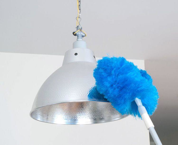 A blue duster cleaning a light fixture, showcasing house cleaning services by Magic Maids in Bremen, AL.