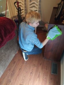 A cleaner dusting wooden furniture in a home by RJ Cleaning Services in Richmond, KY