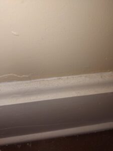 A dusty baseboard along a wall, illustrating an area that will be meticulously cleaned by Maid to Serve HIM in Cincinnati, OH.