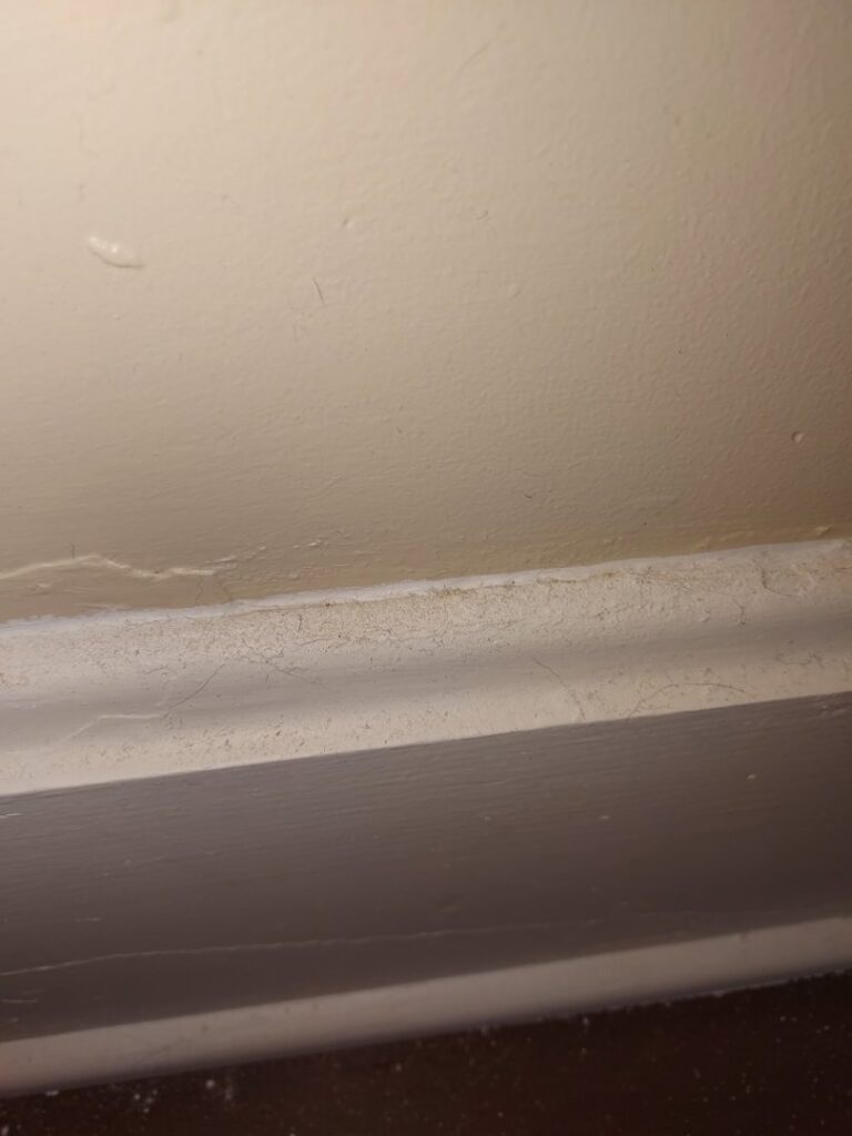 A dusty baseboard along a wall, illustrating an area that will be meticulously cleaned by Maid to Serve HIM in Cincinnati, OH.