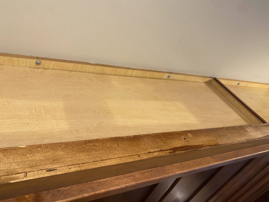 A dusty cabinet top showing an area needing attention before house cleaning by Cuse Cleaning in Syracuse, NY.