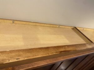 A dusty cabinet top showing an area needing attention before house cleaning by Cuse Cleaning in Syracuse, NY.