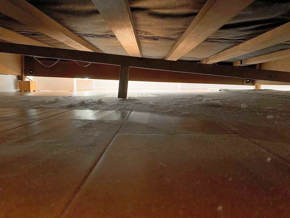 A very dusty floor under a bed, showing accumulated dust and debris before cleaning by Quality Cleaning in Summerville, SC.