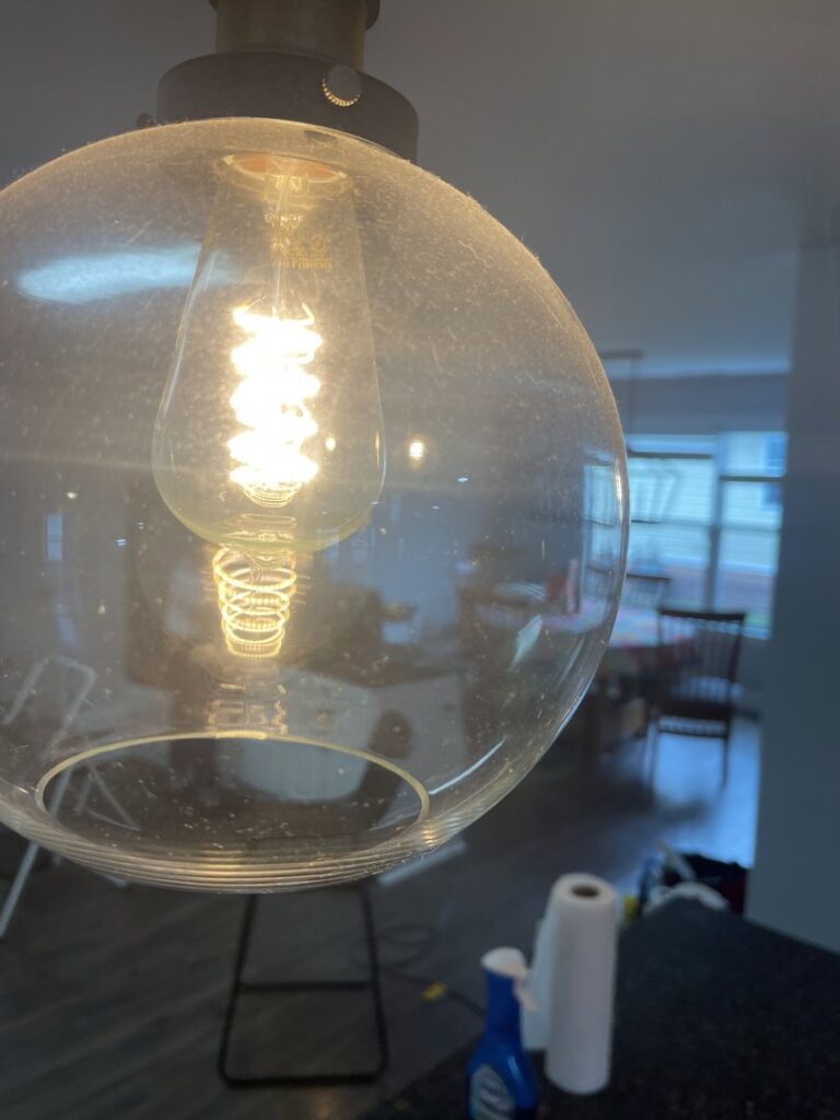 A close-up of a dusty kitchen light fixture, showing the need for detailed cleaning by JLJ Sister's Cleaning & More in Lexington, KY.