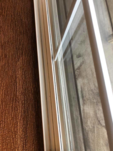 A dusty window frame and screen indicating an area needing cleaning by RA Cleaning Services in Brockton, MA.