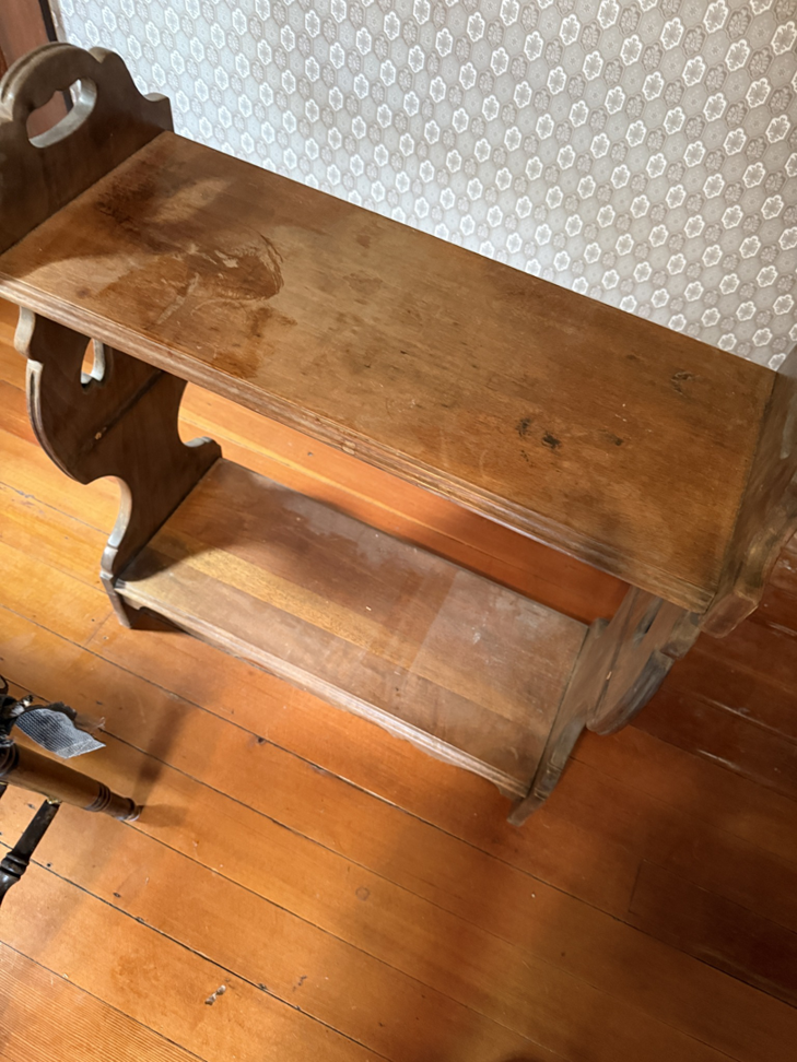 A dusty wooden two-tier shelf unit clearly showing areas needing cleaning by Clean & Clear Pros LLC in Timm Place, USA.