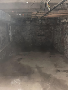 An empty basement showing rough walls and floor, indicating demolition preparation by Identical Demolition LLC in Philadelphia, PA.