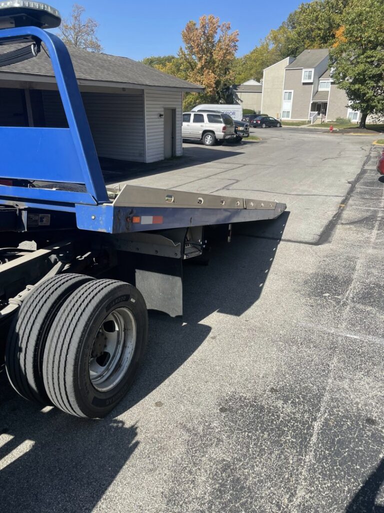 An empty blue flatbed tow truck from Mr.Quickpick Roadside Assistance, ready for towing services in Indianapolis, IN.