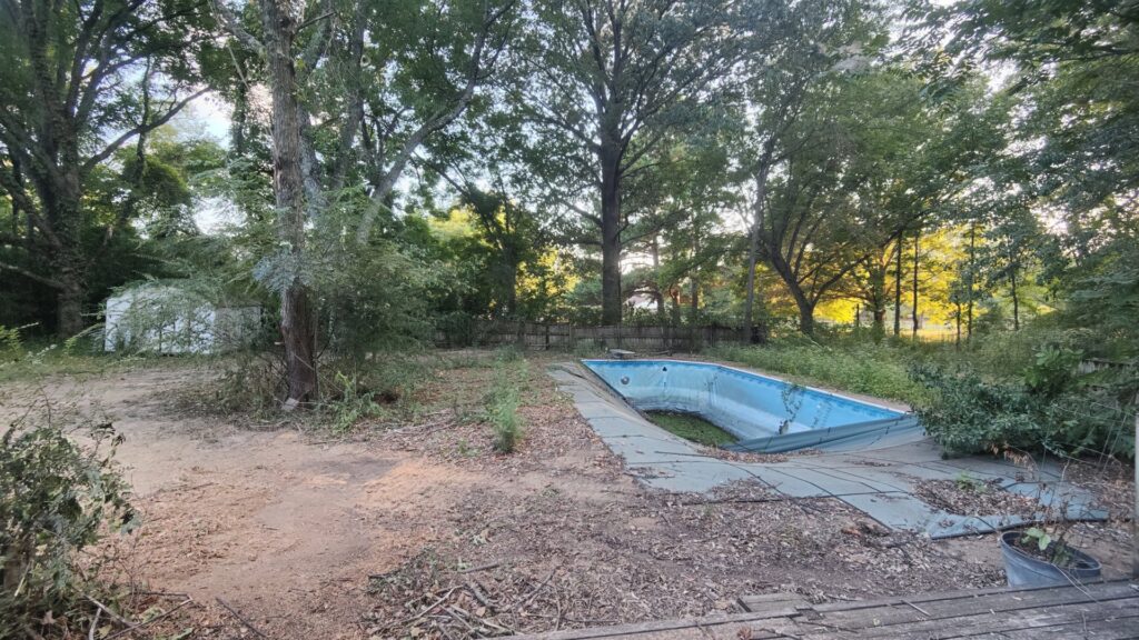 An empty, dirty swimming pool showing its condition before removal by East Shelby Demolition & Pool Removal in Olive Branch, MS.