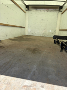 The clean, empty interior of a moving truck with a hand truck, ready for a job by Groovy Movers LLC in Batavia, NY.