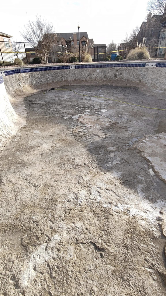 An empty pool with its interior surface prepared for renovation or replastering by J.R. Pools in Lubbock, TX.