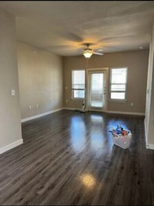 An empty room with hard floors, a cleaning caddy, and a mop, indicating professional house cleaning in progress by Estela's Cleaning Service's in Lake Elmo, MN.