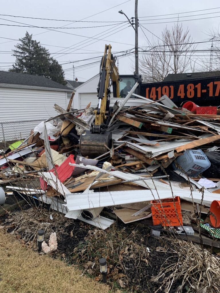 An excavator from Just Take It, LLC. clearing a large pile of demolition debris at a job site in Yorba Linda, CA.