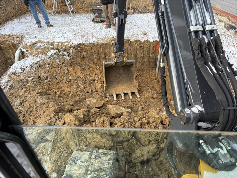 An excavator digging the foundation for a new pool installation by GM Contracting of West Virginia in Morgantown, WV.