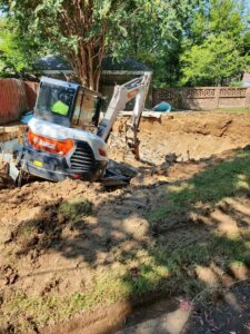 An excavator digging out a swimming pool for removal by East Shelby Demolition & Pool Removal in Olive Branch, MS.