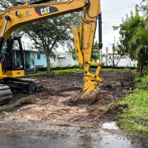 An excavator performing earthwork and site preparation services for New Wave Concepts in Cape Coral, FL.