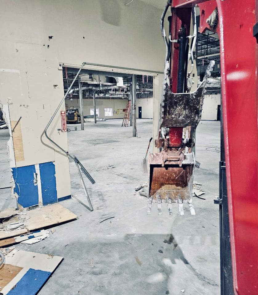 Excavator bucket inside building during interior demolition by Orion Demolition & Environmental Services, LLC in Albany, NY.