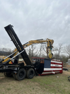 An excavator loading demolition debris into a Pro Dumpster Rentals container in Chattanooga, TN.