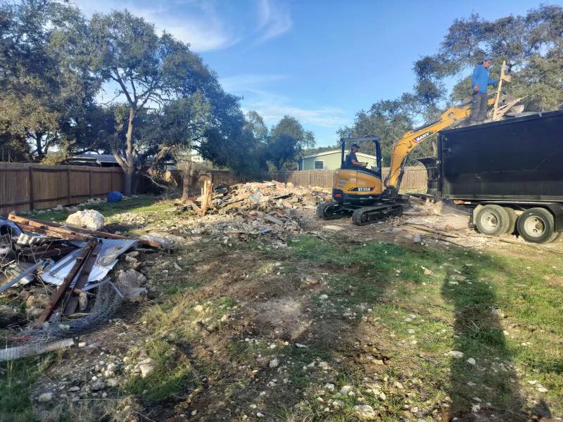 An excavator loading demolition debris into a trailer during cleanup by San Antonio Demolition Pros in San Antonio, TX.