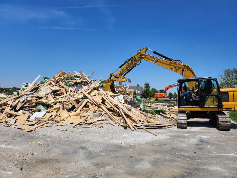 An excavator moving a large pile of demolition debris at a job site for Allis Demolition & Hauling LLC in Omaha, NE