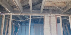 Exposed ceiling joists and wall studs during a restoration project by GOD'S GLORY LLC in Bowie, MD.