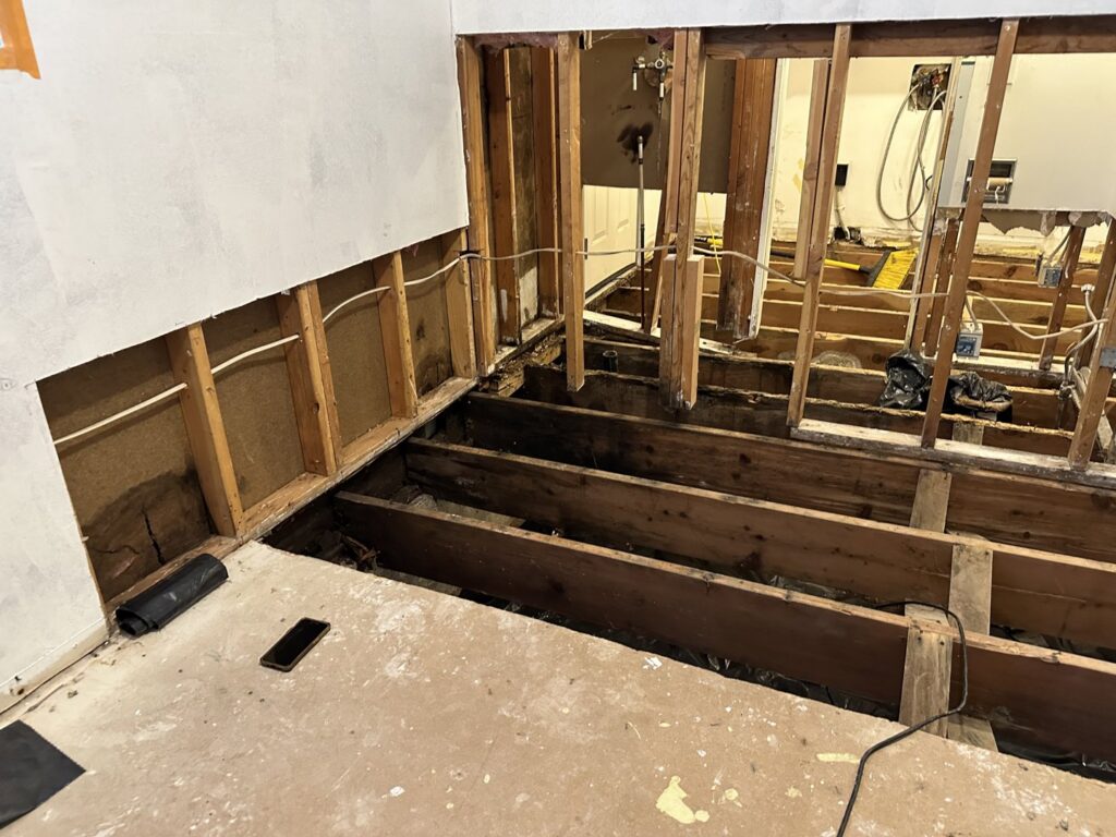 A room with exposed floor joists after demolition due to severe water damage by Restorex in Petaluma, CA.