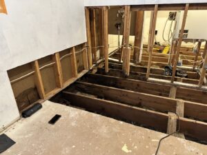 A room with exposed floor joists after demolition due to severe water damage by Restorex in Petaluma, CA.