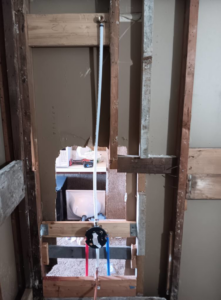 Exposed plumbing pipes and shower valve during water damage repair by Integrity Solutions in Omaha, NE.