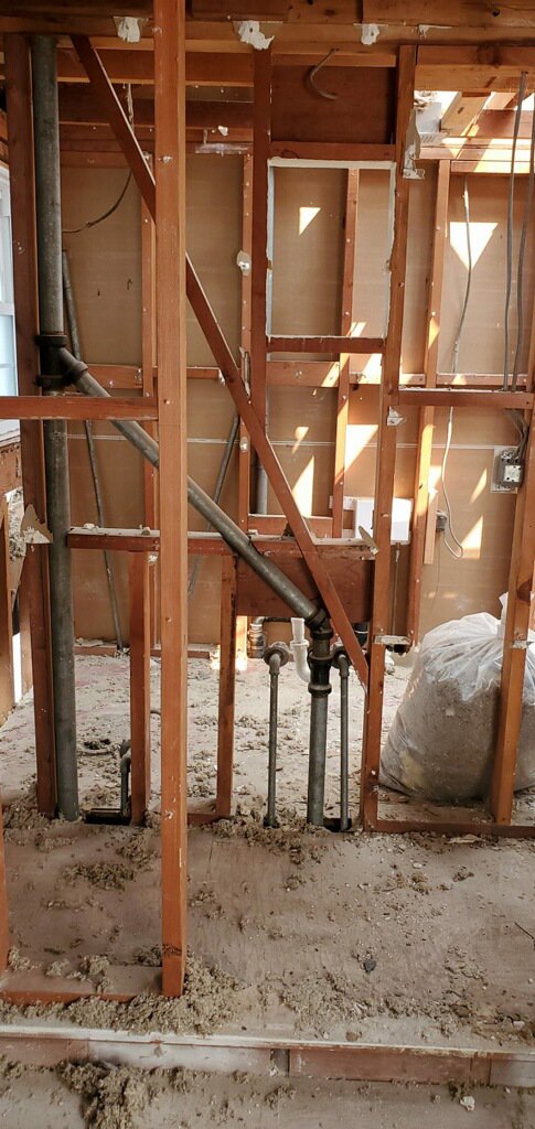 Exposed plumbing and structural framing during water damage remediation by Bordi Restoration in San Leandro, CA