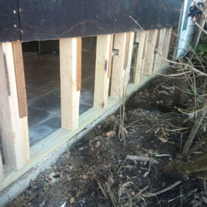 An interior view of a room with exposed wooden studs, indicating a demolition or restoration phase after water damage, handled by Ciocca Cleaning & Restoration in Fort Wayne, IN.