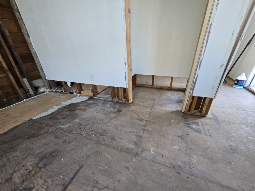 An interior room with exposed subfloor and wall studs during water damage remediation by Harbaugh Restoration in Vancouver, WA.