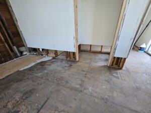An interior room with exposed subfloor and wall studs during water damage remediation by Harbaugh Restoration in Vancouver, WA.