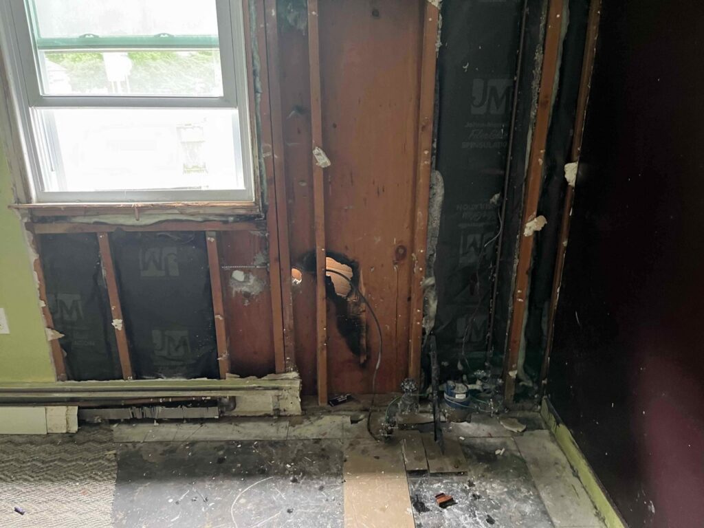 An exposed wall with removed drywall showing water damage during remediation by RestoPros of Hartford in West Hartford, CT.