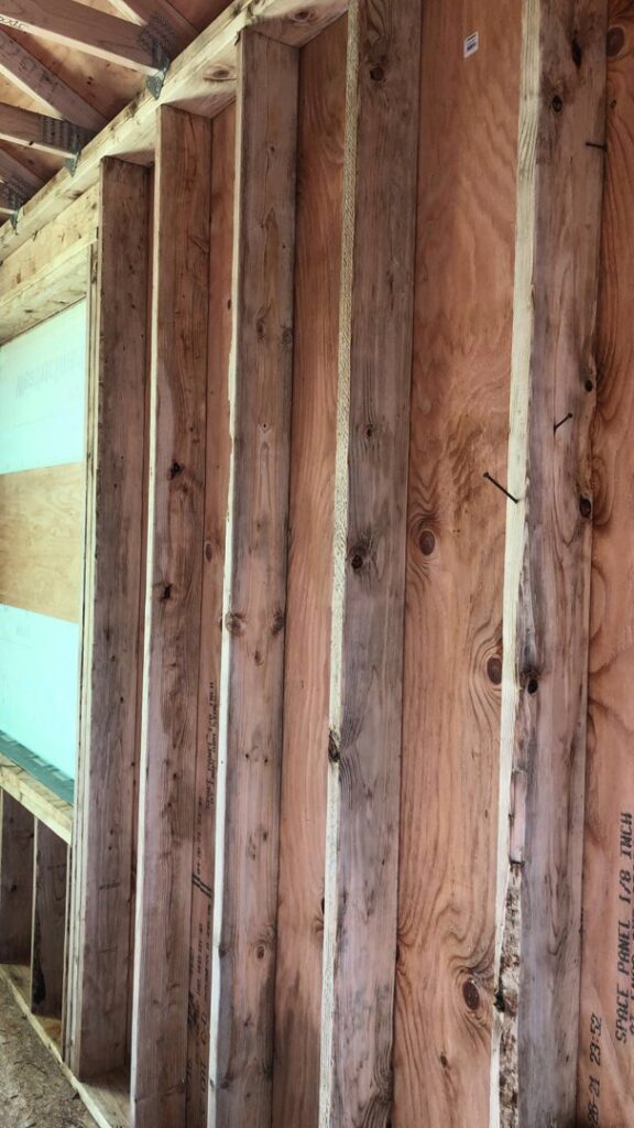 Exposed wall studs and sheathing showing water damage, part of remediation by Quality Remediation llc in Everett, WA