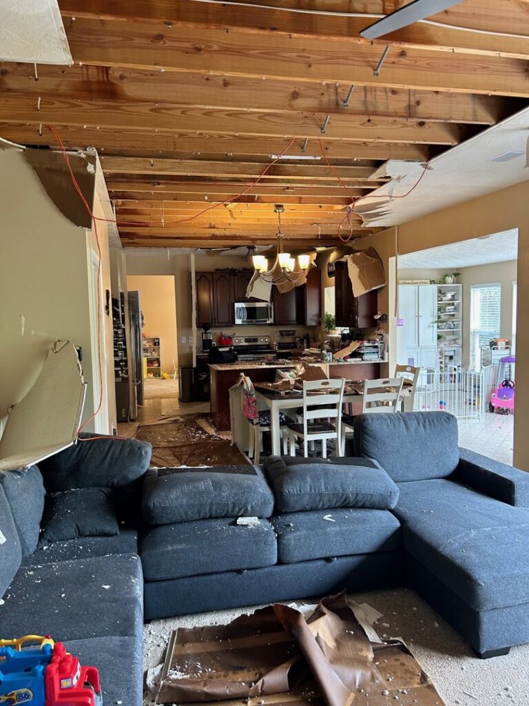 Extensive water damage in a living room and kitchen with a collapsed ceiling, handled by Triple Crown Restoration in Covington, KY