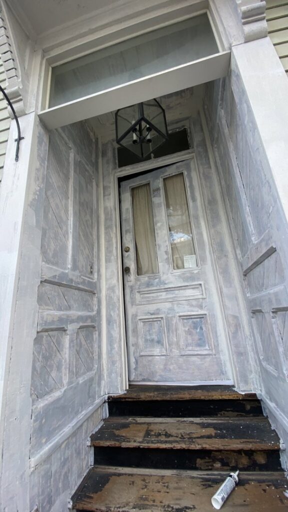 An exterior door frame undergoing water damage repair and preparation for painting by Empire Pro Painting Inc. in Lynn, MA.