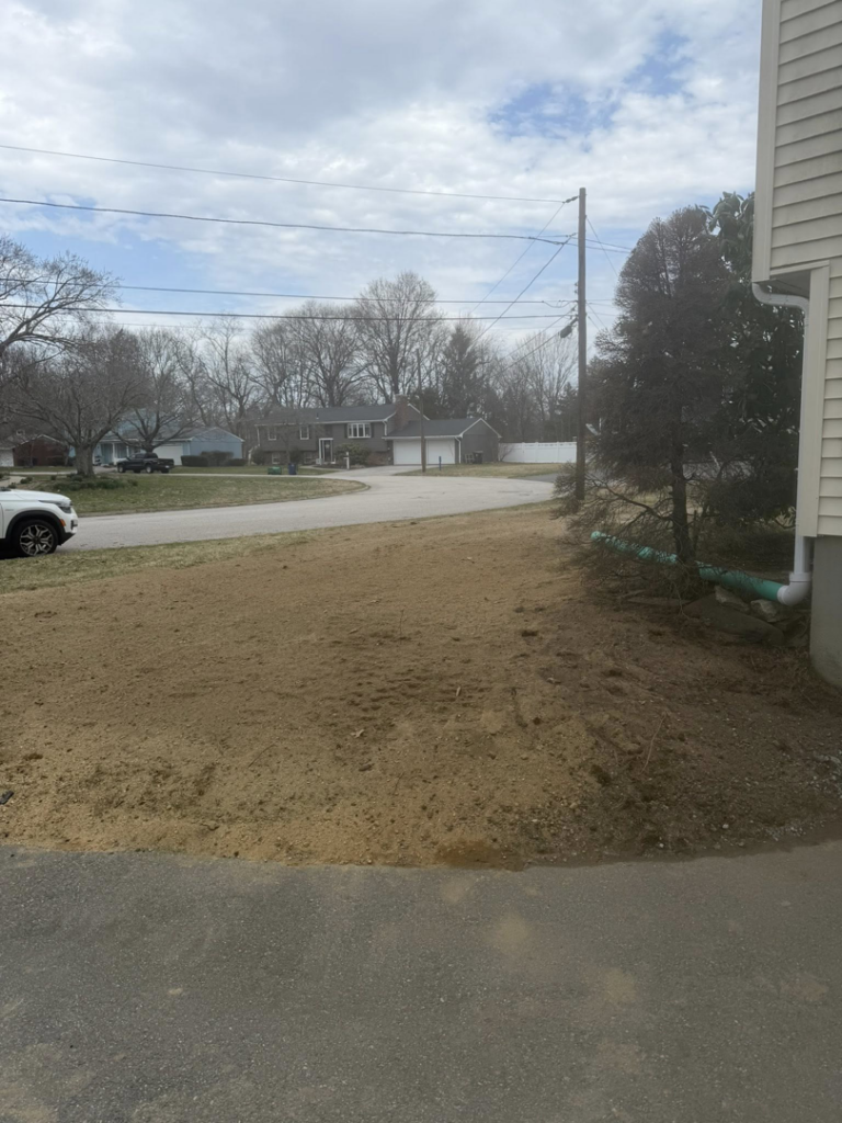 An exterior drainage pipe installed next to a house by Fleury Dirt Works & Services Llc in Cumberland, RI