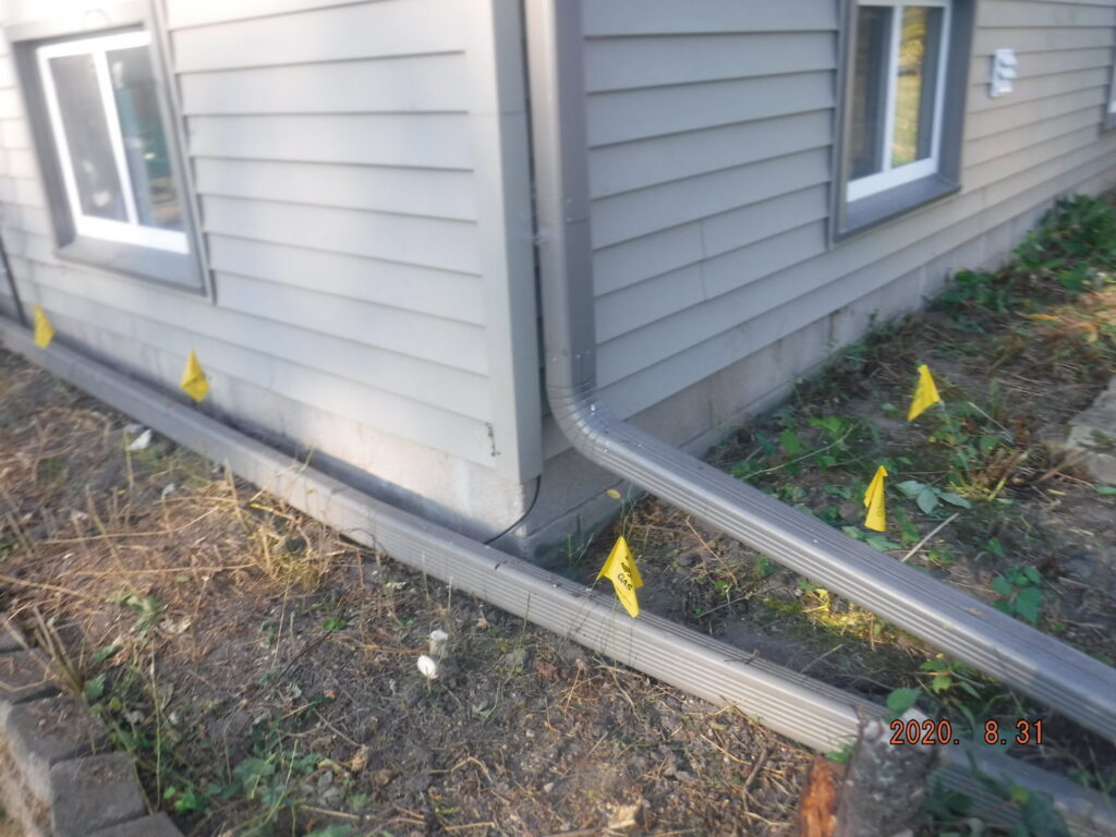Exterior drainage system installation with downspouts and marked areas by Waterdry Indiana in South Bend, IN