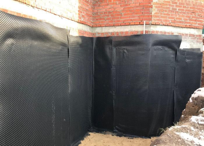 Exterior foundation wall being waterproofed with a black dimpled membrane by Fort Wayne Foundation Repair Experts in Fort Wayne, IN.