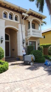 A cleaner from RK Cleaning Services performing exterior house cleaning in Fort Lauderdale, FL.
