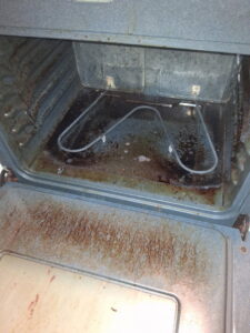 An extremely greasy and grimy oven interior, illustrating a challenging before-cleaning scenario for CleanSlate Cleaning Company in Lansing, MI.